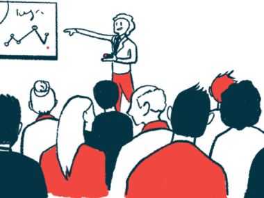 A speaker points to a presentation in front of an audience.