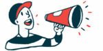 A man wearing a ballcap speaks into a megaphone to get a message out.